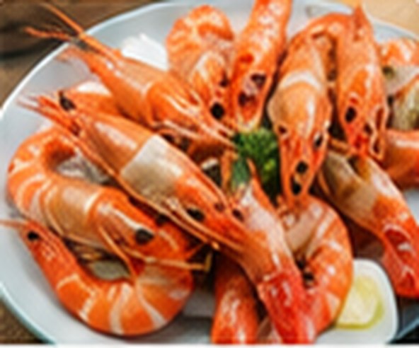A plate of cooked king prawns with parsley.